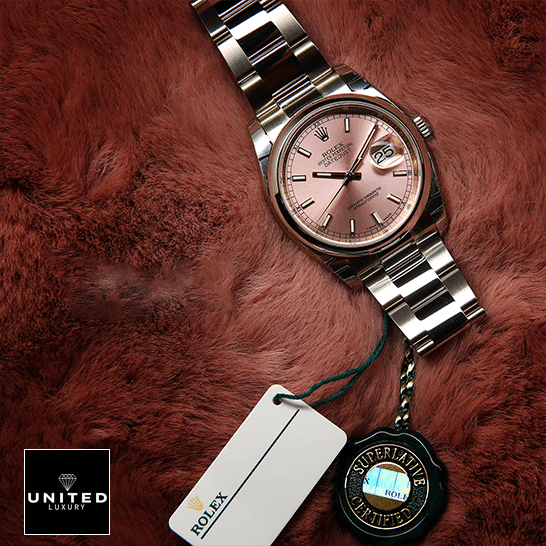 Rolex Datejust 116200 Pink Dial Inspired next to the quarantine card on soft ground